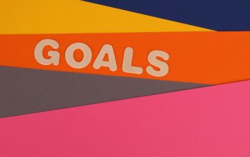 Vibrant abstract image with the word 'Goals' on multi-colored paper background.
